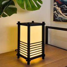 a lamp that is sitting on top of a table next to a potted plant