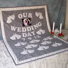 a wedding day quilt on a bed with candles and flowers in front of the photo