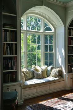 a window seat in the corner of a room with bookshelves on either side