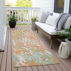 an outdoor area rug on a porch with potted plants