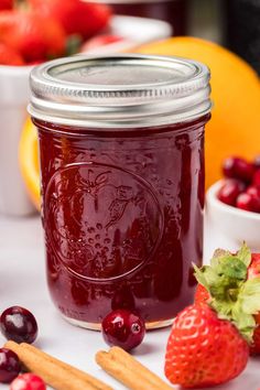 cranberry sauce in a mason jar surrounded by fresh fruit