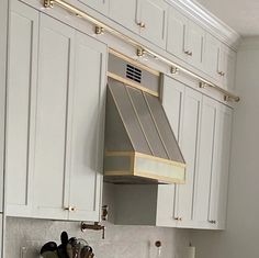 a stove top oven sitting inside of a kitchen next to white cabinets and counter tops