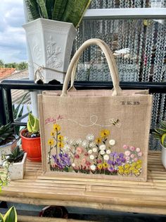 a bag sitting on top of a wooden table next to plants and potted plants