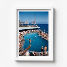 a group of people standing around a swimming pool in the ocean next to a pier