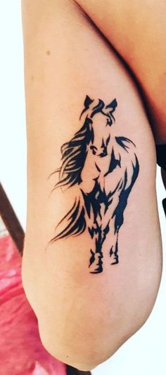 a woman's leg with a tattoo of a horse on the back of it