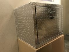 a metal cabinet sitting in the corner of a room next to a wall with a window