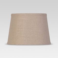 a lamp shade on a white background with a light brown linen covering the top part