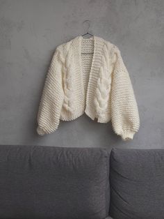 a white sweater hanging on a gray wall