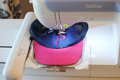 a pink and blue hat sitting on top of a sewing machine