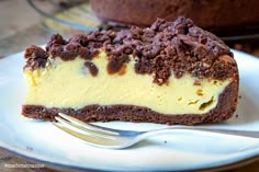 a piece of chocolate cheesecake on a plate with a fork next to the cake