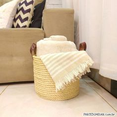 a basket with towels on the floor next to a couch