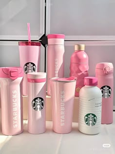 several pink starbucks tumblers and cups are arranged on the counter next to each other