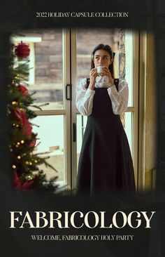 a woman standing in front of a window holding a cup