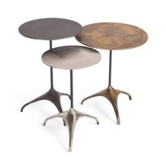 three tables with metal legs on each side and two different colored tops, one in the shape of an antelope