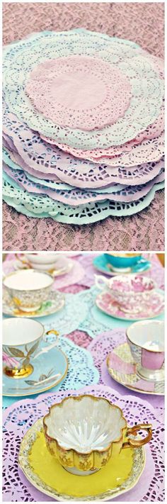 there are many different plates and cups on the table with lace doily around them