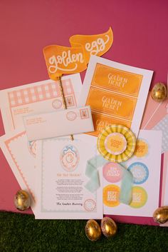 an assortment of cards and envelopes on the ground next to some gold foil eggs