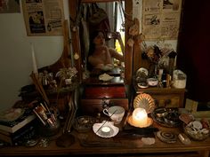 a woman is sitting in front of a dresser full of clutter and other items