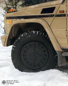 an off - road vehicle parked in the snow with its wheels on it's tires