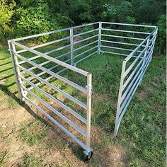 a small metal cage with wheels in the grass