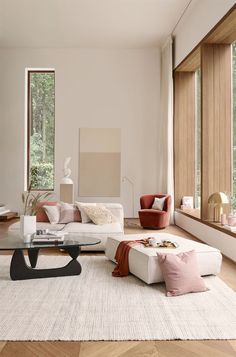 a living room filled with lots of furniture next to large windows on the side of a wall