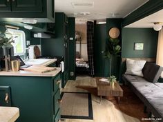 a living room with green walls and wood flooring in the kitchen, dining area