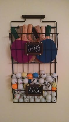 a rack with two ping pong paddles and some balls in it on the wall