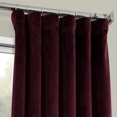 a close up view of a curtain with dark red velvet curtains in front of a window