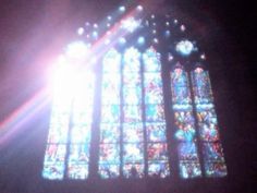 the sun shines brightly in front of a stained glass window