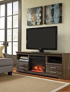 a living room with a couch, chair and flat screen tv on top of it