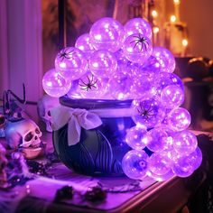 a potted plant filled with lots of purple balloons on top of a wooden table