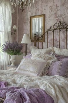 a bed with purple and white comforter in a bedroom next to a window, chandelier and mirror