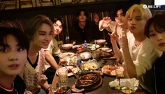 a group of people sitting around a table with food and drinks in front of them