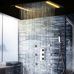 a shower head with rain coming out of it and some lights on the wall above it