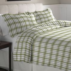 a bed with green and white plaid sheets