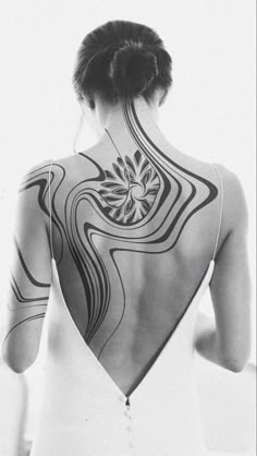 the back of a woman's body with tattoos on it