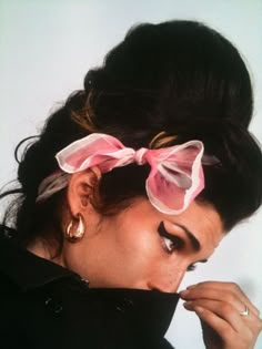 a woman with her hair in a bun and pink bow tie