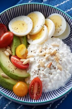 a bowl filled with rice, cucumber, tomatoes and hard boiled eggs