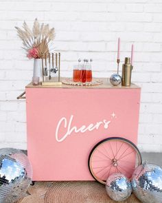 a pink ice cream cart with disco balls and candles on the floor next to it