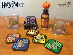 harry potter themed coasters are on a table next to two mugs and a bottle