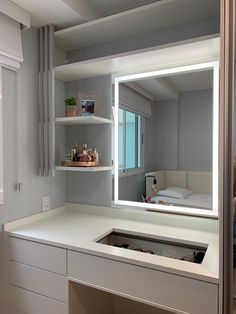 a bathroom with a sink, mirror and shelving unit on the wall in front of it