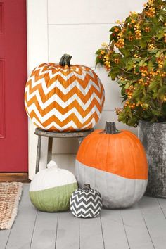 three pumpkins are sitting on the porch