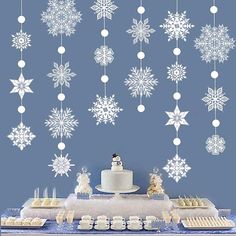 a table topped with cake and cupcakes covered in frosting snowflakes