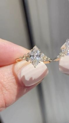 a woman's hand holding two engagement rings