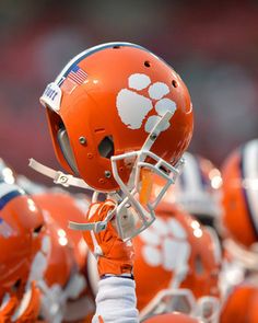 an orange and white football team is lined up on the field with their helmets down