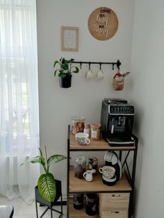 there is a coffee maker and some cups on the shelf in this room with white walls