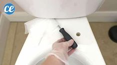 a person using a toilet brush to clean it