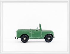 a green toy truck sitting on top of a white surface