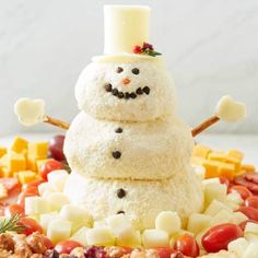 a snowman made out of food on top of a pile of fruit and vegetables