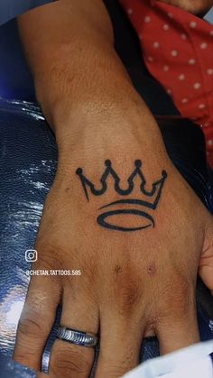 a hand with a crown tattoo on it