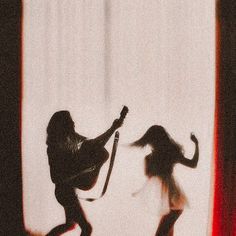 black and white photograph of two women playing guitar in front of a window with curtains